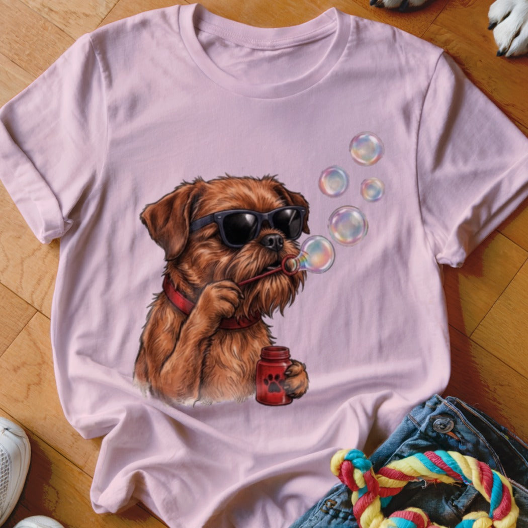 A light pink t-shirt featuring an illustration of a brown dog wearing sunglasses and blowing bubbles.