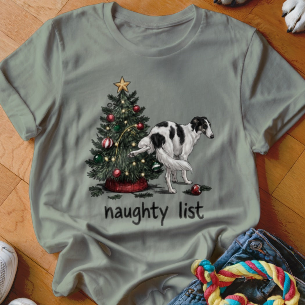 Sage green crewneck t-shirt featuring a graphic of a borzoi dog lifting its leg on a Christmas tree, with the text "naughty list" underneath.