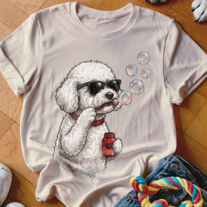 Light-colored t-shirt featuring a cartoon illustration of a fluffy poodle wearing sunglasses and blowing bubbles.