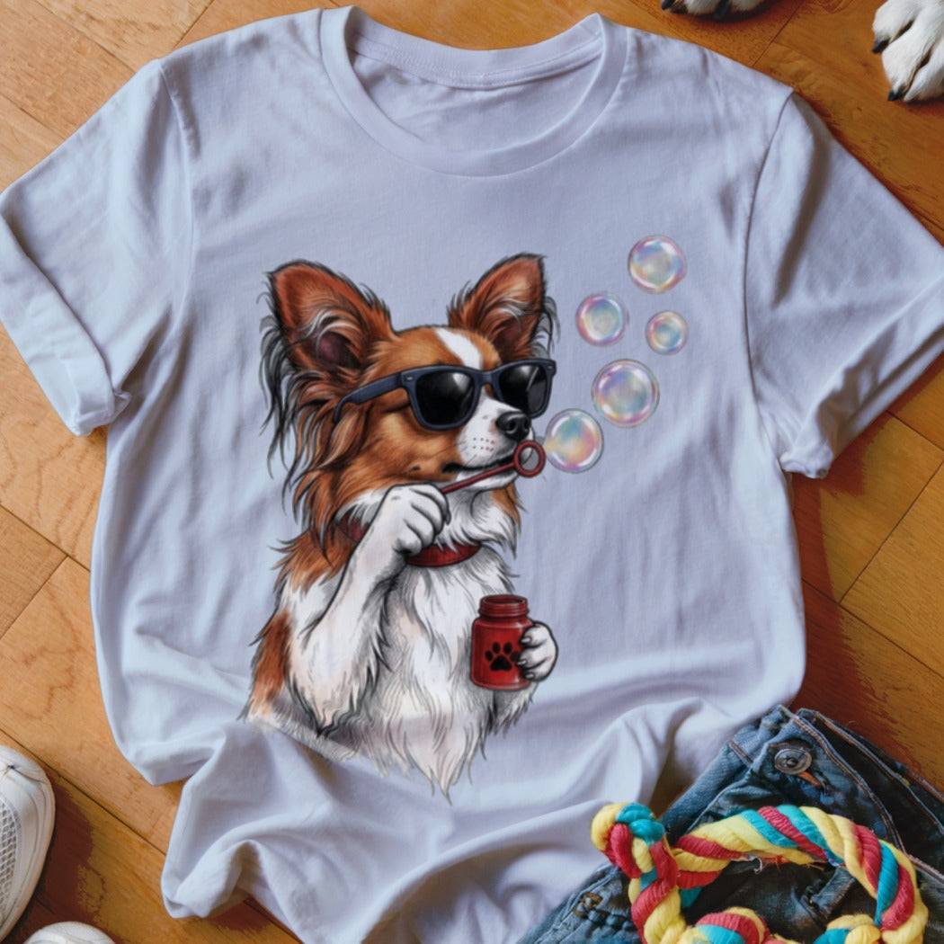 White short-sleeve t-shirt featuring a graphic of a brown and white dog wearing sunglasses blowing bubbles.