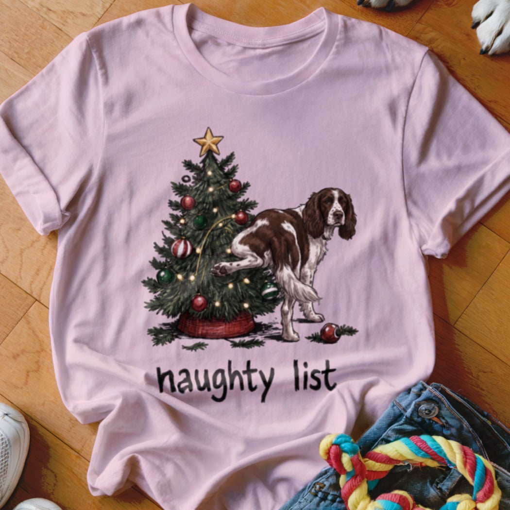 Brown and white dog by a Christmas tree with the text "naughty list".