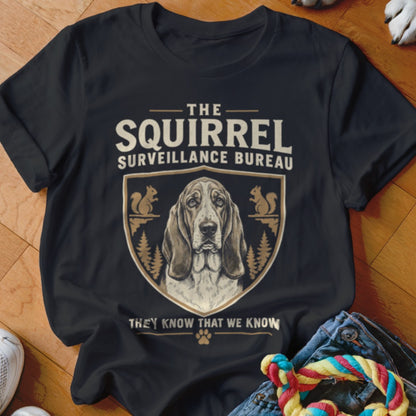 Black crewneck t-shirt featuring a basset hound crest with text reading The Squirrel Surveillance Bureau.