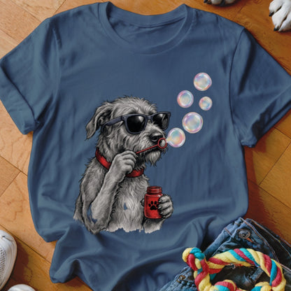 A blue t-shirt printed with a graphic of a scruffy grey dog wearing sunglasses and blowing bubbles.