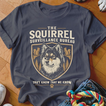 A charcoal grey t-shirt featuring a crest with a dog, squirrels, and the text The Squirrel Surveillance Bureau.