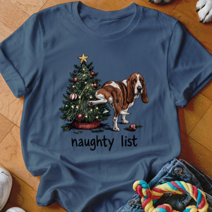 Basset Hound standing next to a Christmas tree with ornaments, text reads "naughty list".