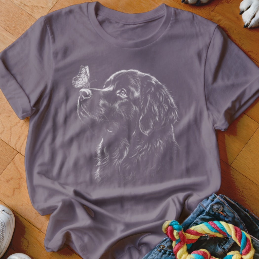Purple t-shirt featuring a white graphic of a dog looking at a butterfly on its nose.