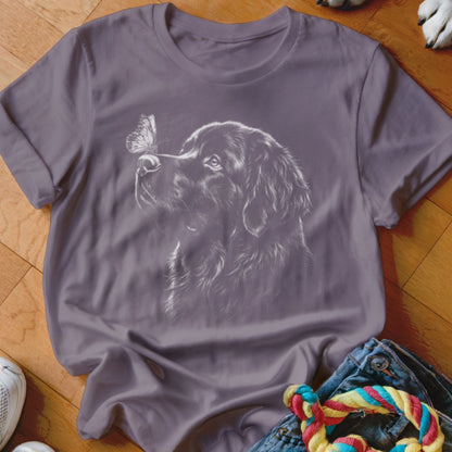 Purple t-shirt featuring a white graphic of a dog looking at a butterfly on its nose.
