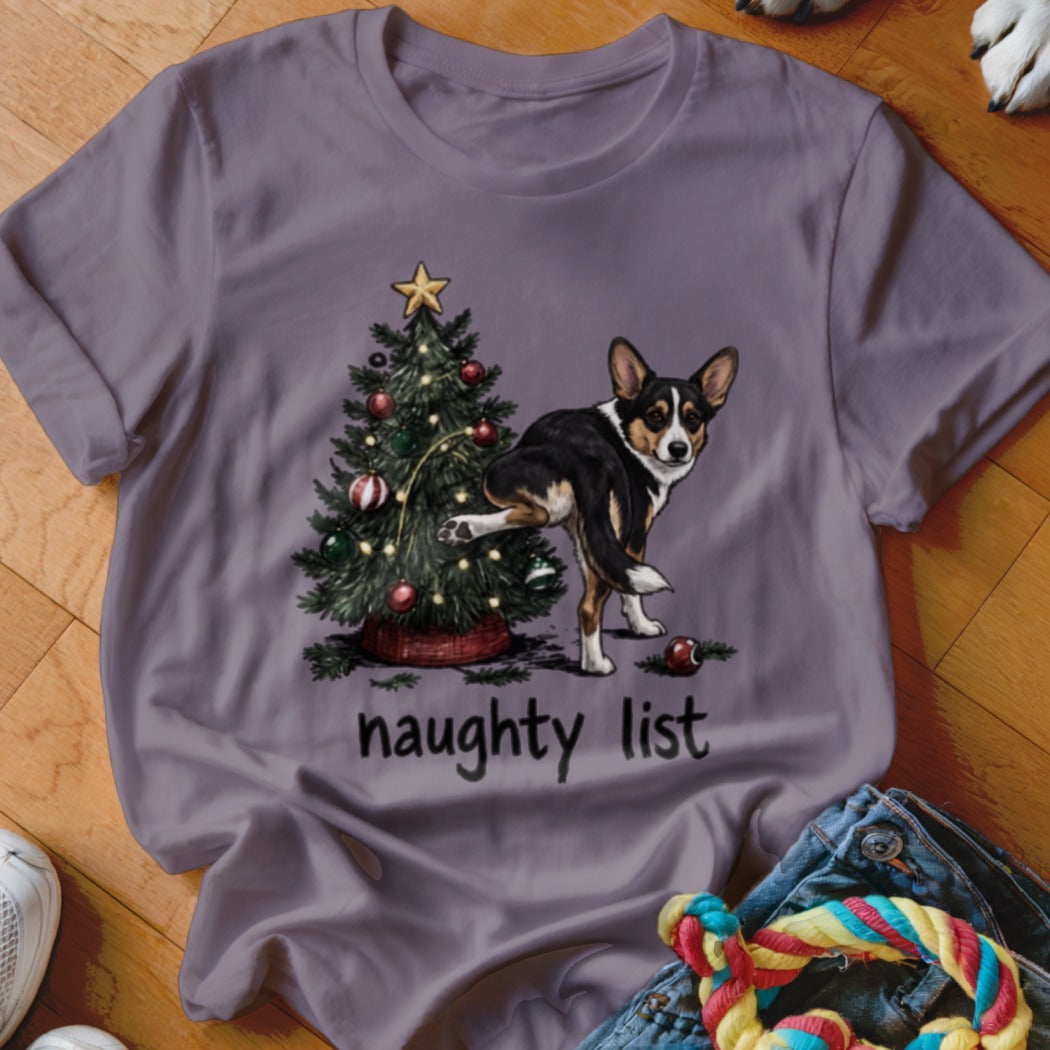 Tricolor dog lifting leg near Christmas tree with text "naughty list".