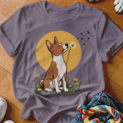 Mauve t-shirt featuring an illustration of a brown and white dog blowing dandelion seeds against a yellow circle background.