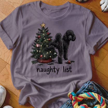 Black poodle standing next to a Christmas tree with "naughty list" text.