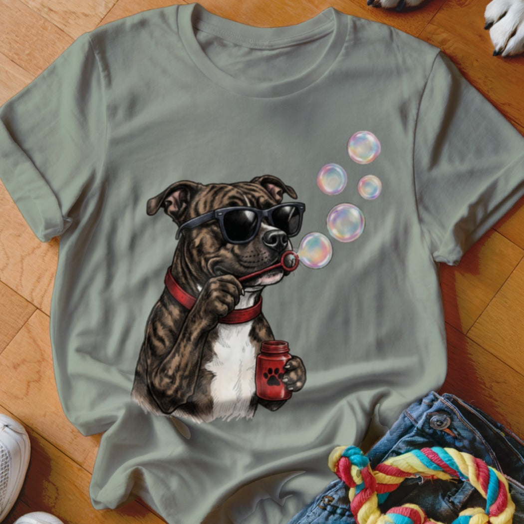 Sage green t-shirt featuring a graphic of a brindle pitbull wearing sunglasses and blowing soap bubbles.