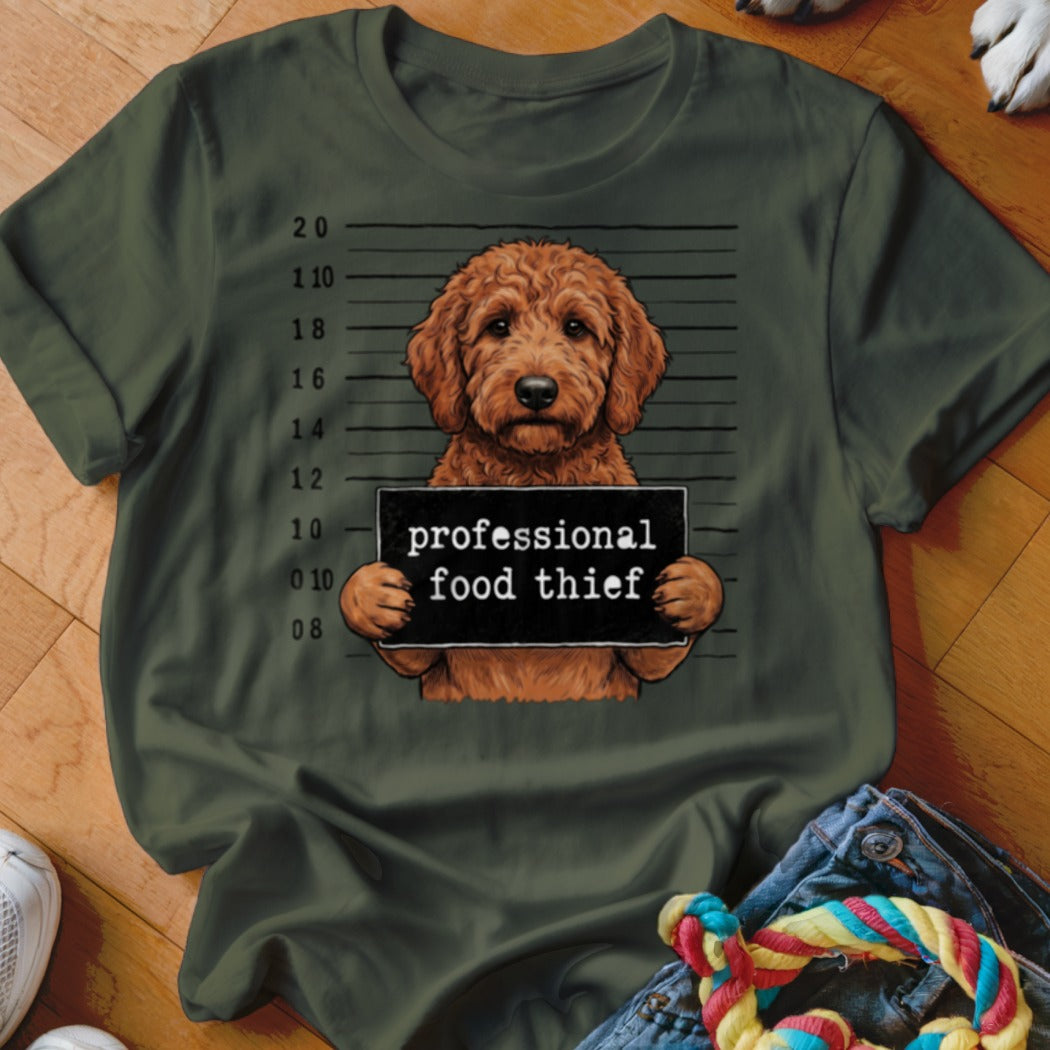 Goldendoodle in mugshot holding "professional food thief" sign.
