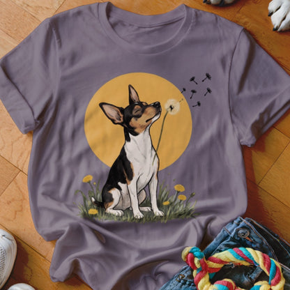 A grey crewneck t-shirt featuring an illustration of a small dog blowing dandelion seeds.