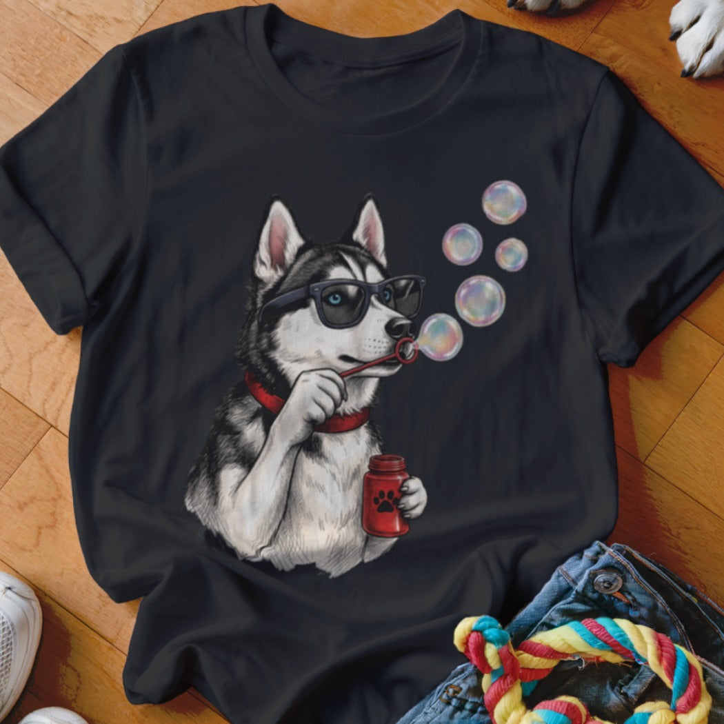A black t-shirt printed with a graphic of a husky wearing sunglasses and blowing bubbles.