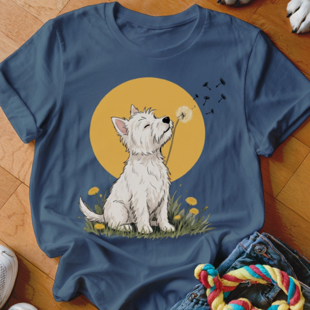 A dark blue t-shirt printed with a graphic of a white West Highland Terrier blowing dandelion seeds against a yellow circle.