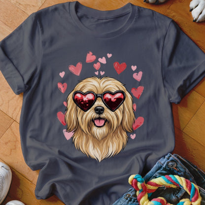 A dark gray t-shirt featuring an illustration of a fluffy golden dog wearing heart-shaped sunglasses surrounded by pink hearts.
