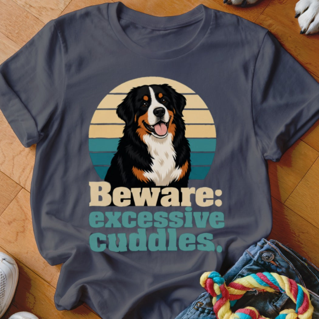 Bernese Mountain Dog graphic with text "Beware: excessive cuddles" on a dark blue t-shirt.