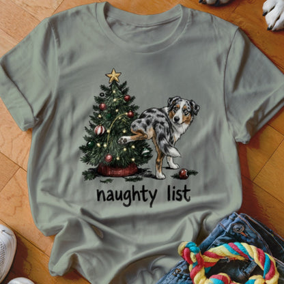 Merle Australian Shepherd lifting leg on Christmas tree, text says "naughty list."