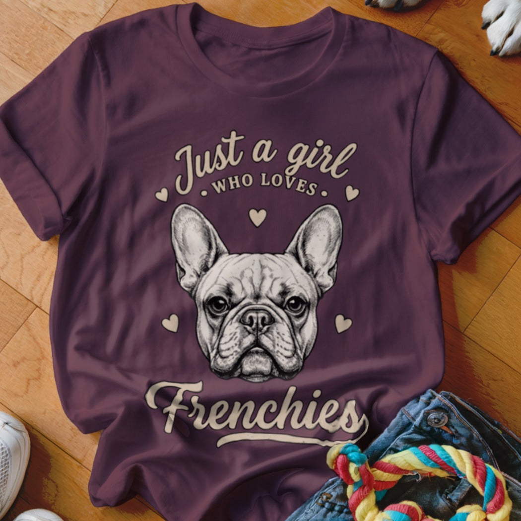 Maroon short-sleeved t-shirt featuring a French bulldog graphic and text that reads "Just a girl who loves Frenchies".