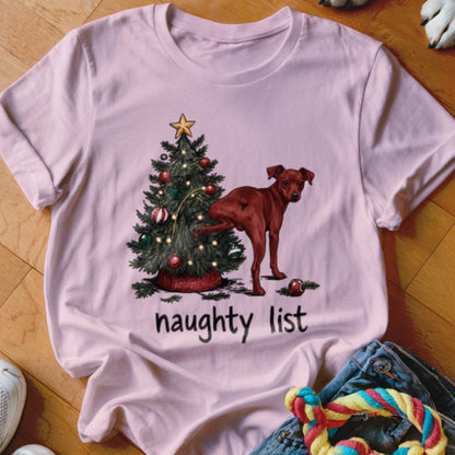 Pink t-shirt with a dog peeing on a Christmas tree and the words "naughty list."