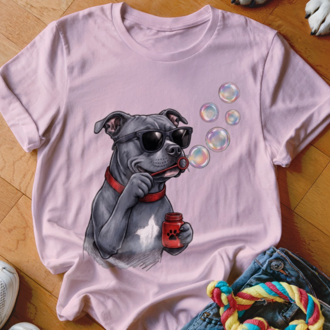 Light pink t-shirt featuring an illustrated grey pit bull wearing sunglasses and blowing soap bubbles.
