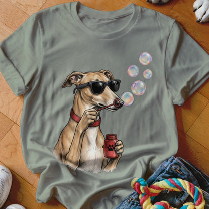 A sage green t-shirt features a graphic of a dog wearing sunglasses and blowing bubbles.
