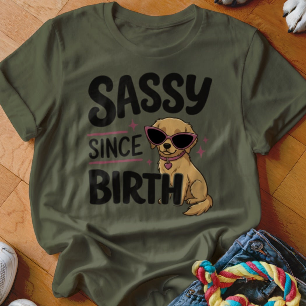 Olive green t-shirt with "SASSY SINCE BIRTH" text and a cartoon dog wearing sunglasses.