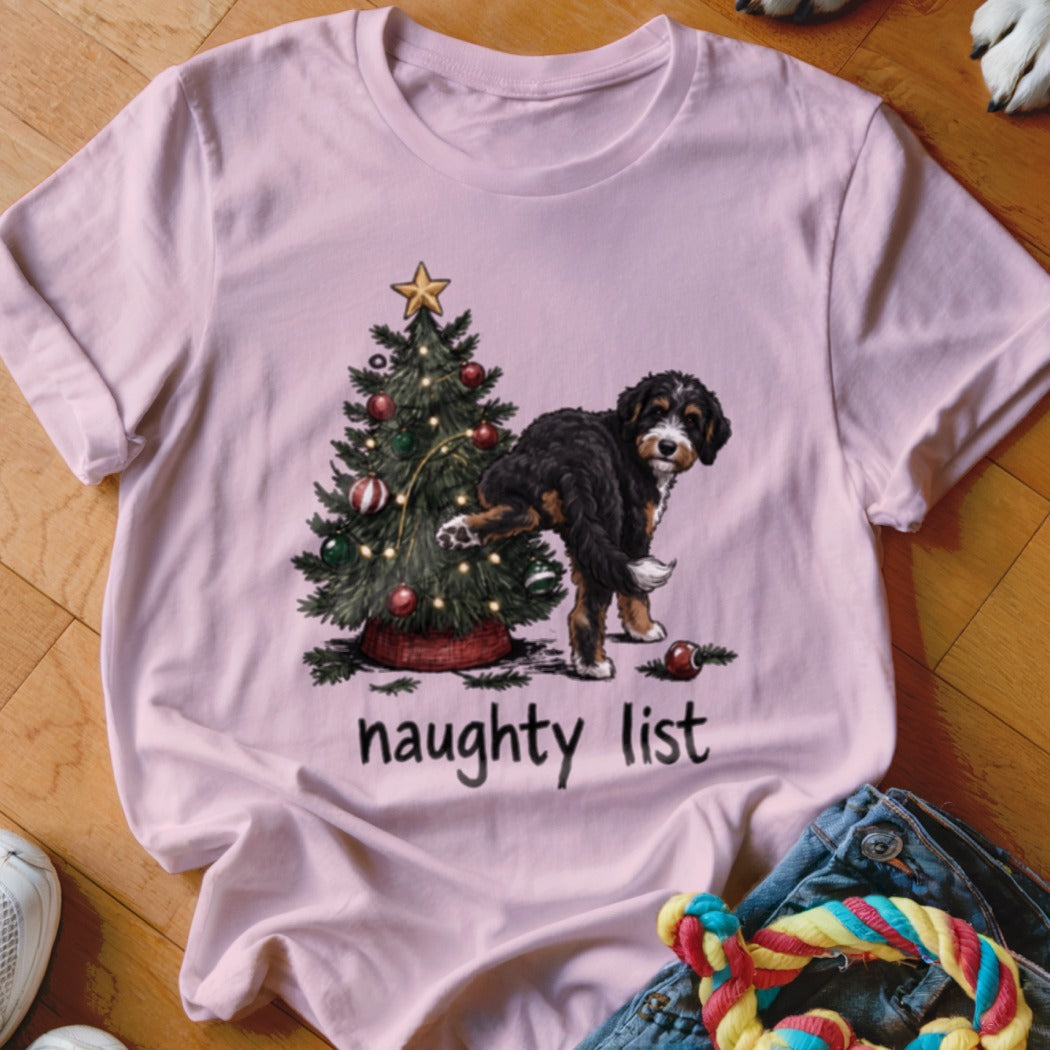 Pink t-shirt with a dog at a Christmas tree and the words "naughty list."