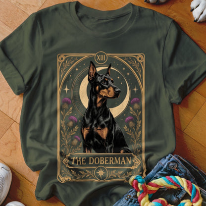 Dark green t-shirt featuring a tarot card graphic of a Doberman surrounded by thistles and a crescent moon.
