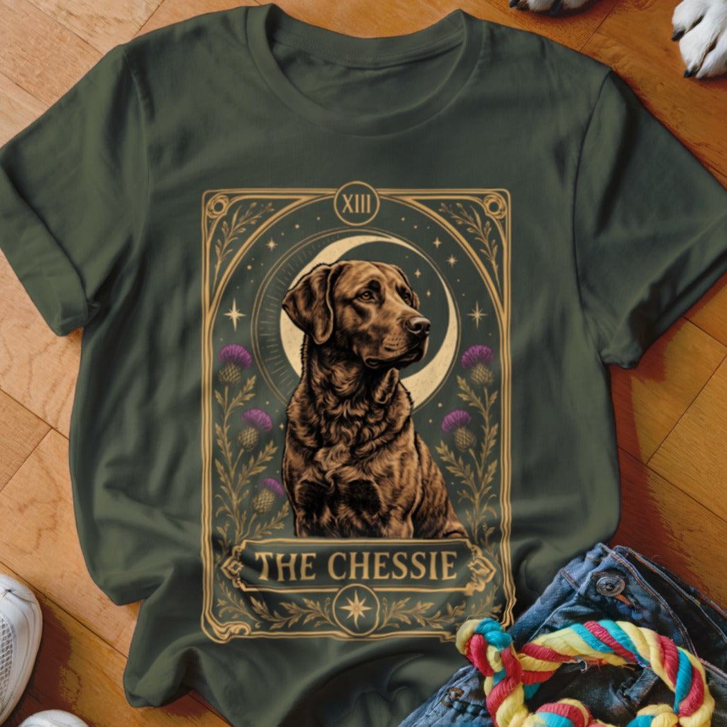 Dark green t-shirt featuring a tarot-style graphic of a Chesapeake Bay Retriever, crescent moon, and thistles with text reading The Chessie.