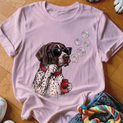 A light pink t-shirt features a graphic of a spotted dog wearing sunglasses and blowing soap bubbles.