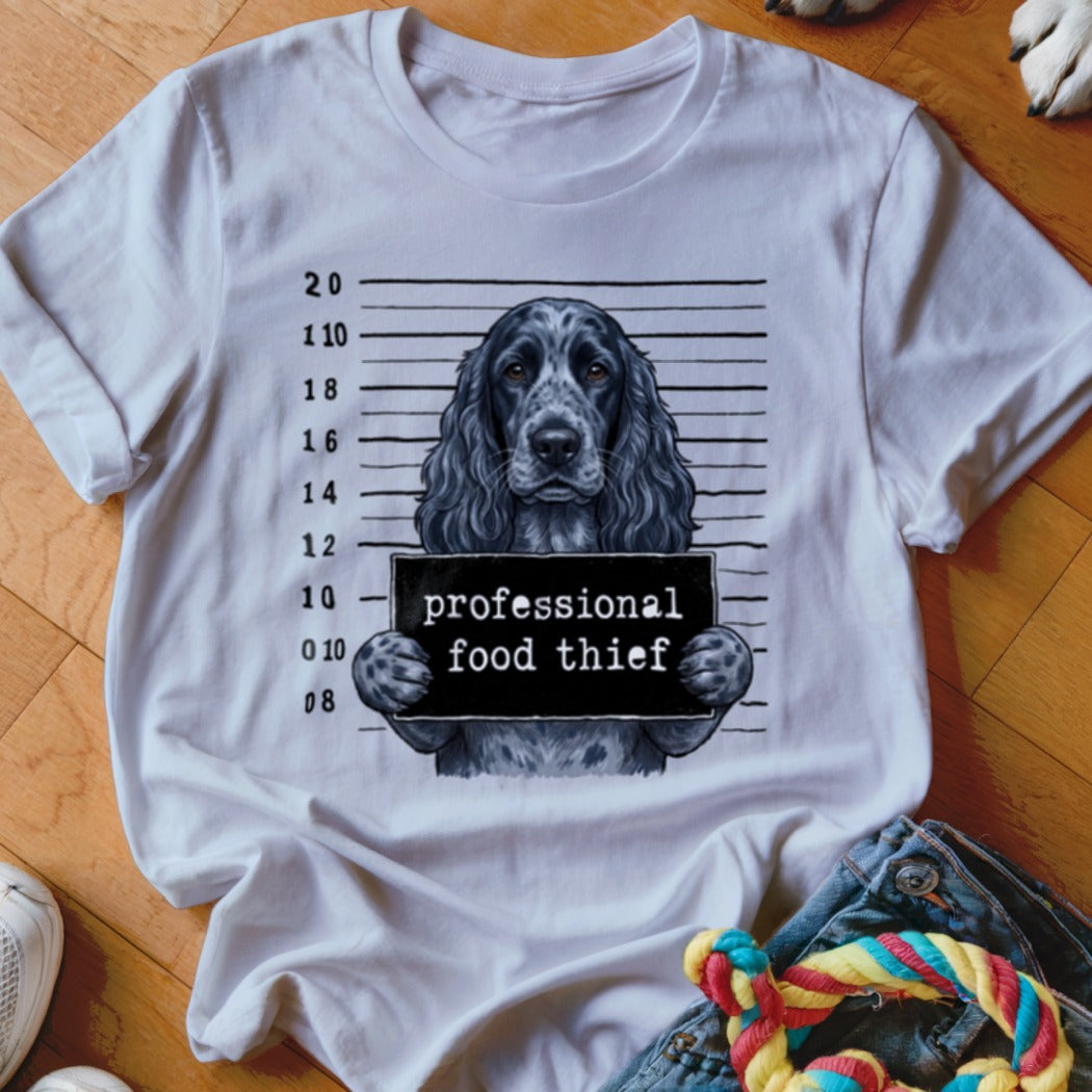 Dog wearing a mugshot sign that says "professional food thief."