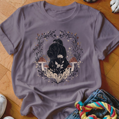 A dusty purple t-shirt featuring a graphic of a black dog surrounded by mushrooms and leafy branches.