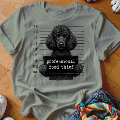 Black poodle mugshot with "professional food thief" sign.