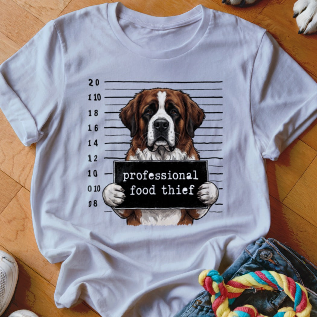 Saint Bernard dog mugshot with "professional food thief" sign on a t-shirt.