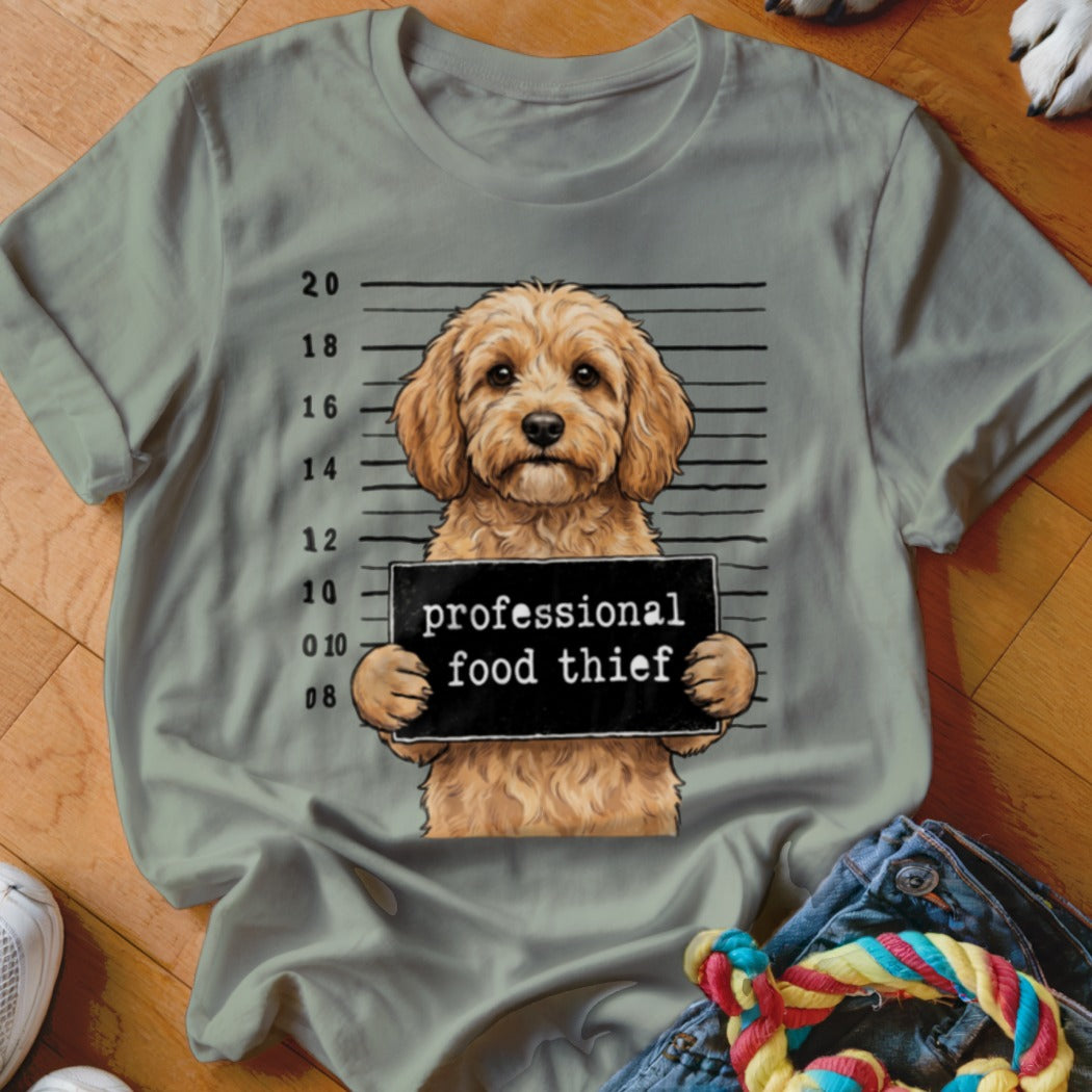 Goldendoodle dog mugshot holding a sign reading "professional food thief".