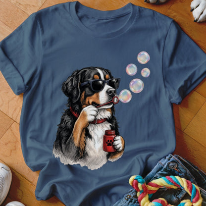 Blue t-shirt featuring a graphic of a Bernese Mountain Dog wearing sunglasses and blowing soap bubbles.
