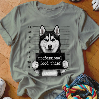 Husky in mugshot holding sign "professional food thief".