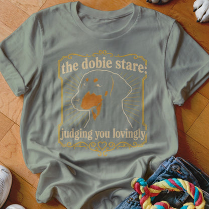 Grey t-shirt with "the dobie stare: judging you lovingly" text and dog graphic.