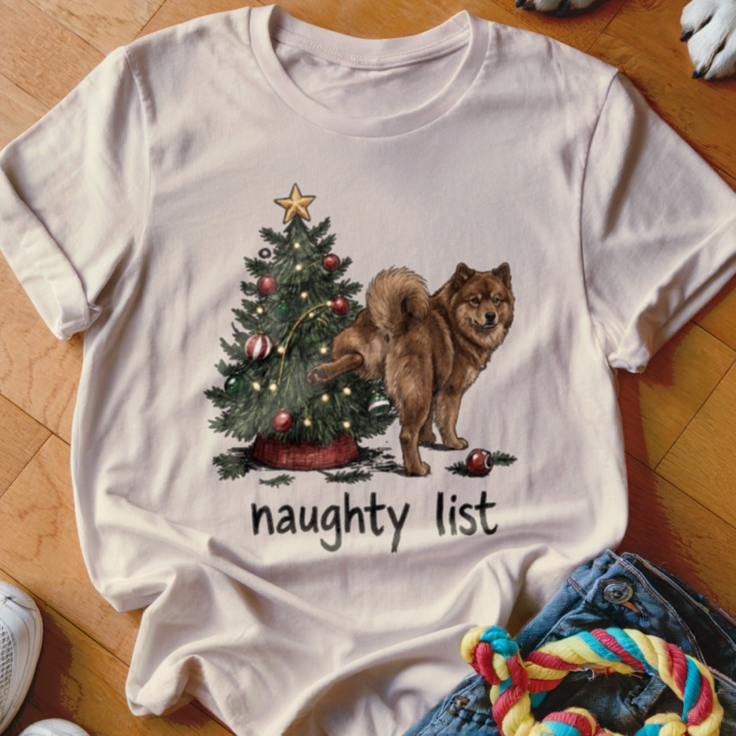 White t-shirt with graphic of dog by Christmas tree, text "naughty list".