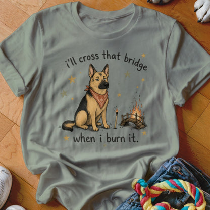 German Shepherd with bandana sitting by a burning bridge and text "I'll cross that bridge when I burn it."