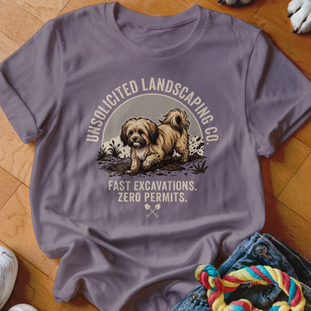 T-shirt graphic: fluffy dog digging in dirt, "Unsolicited Landscaping Co." text.
