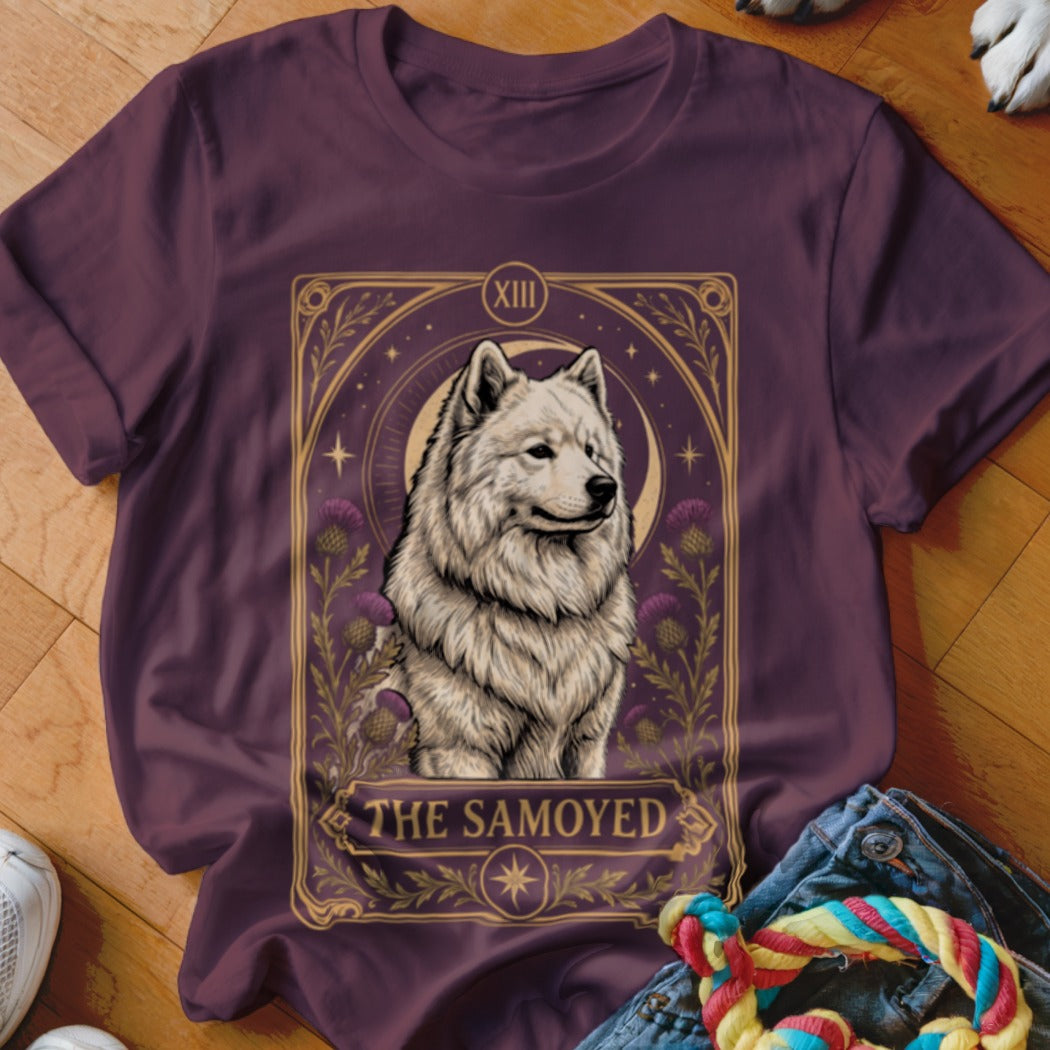 A dark purple t-shirt featuring a tarot card graphic of a Samoyed dog surrounded by thistles.