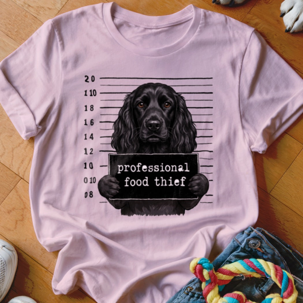 Black dog mugshot graphic with "professional food thief" text on a pink t-shirt.