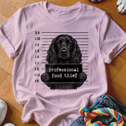 Black dog mugshot graphic with "professional food thief" text on a pink t-shirt.
