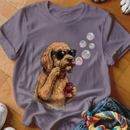 A purple t-shirt featuring a graphic of a golden doodle wearing sunglasses and blowing bubbles.