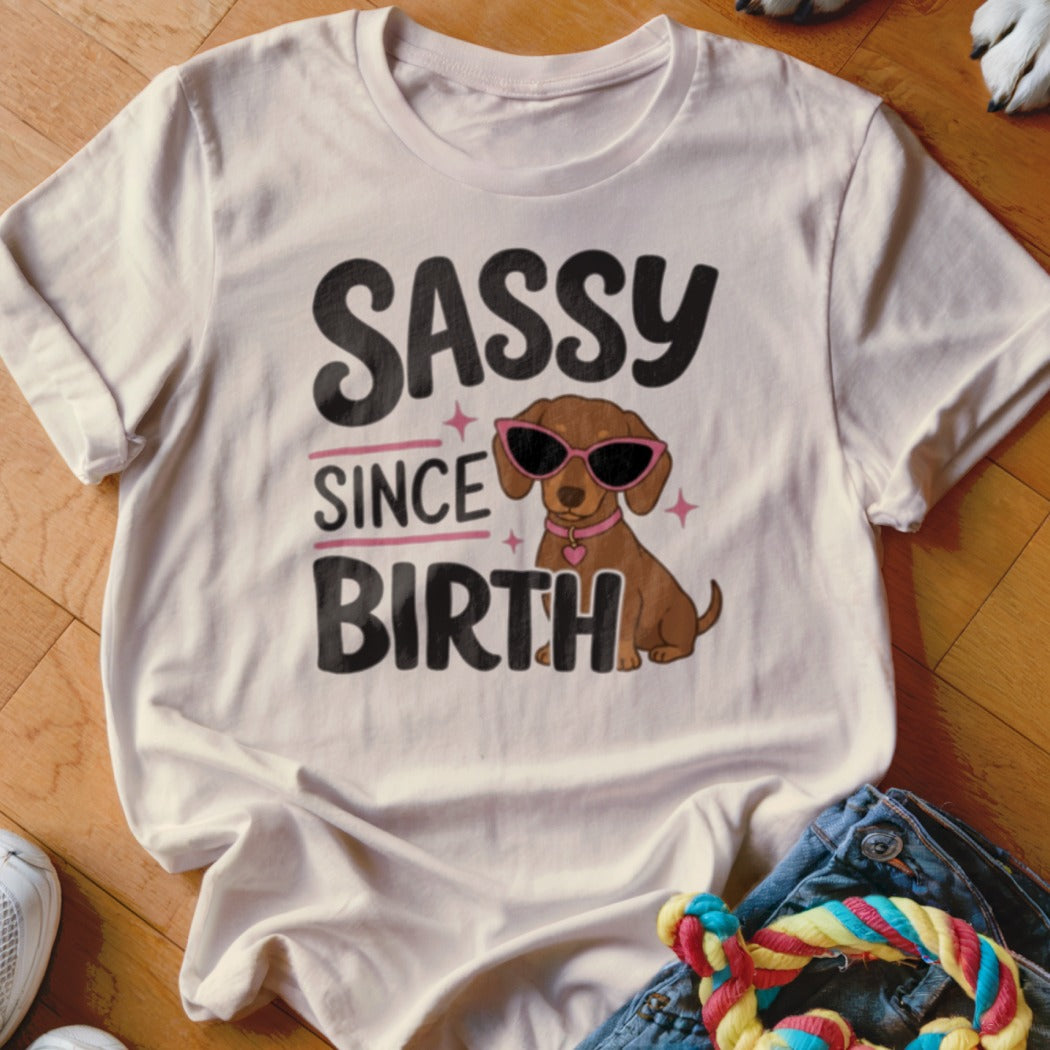 White t-shirt with dachshund wearing sunglasses and text "Sassy Since Birth".