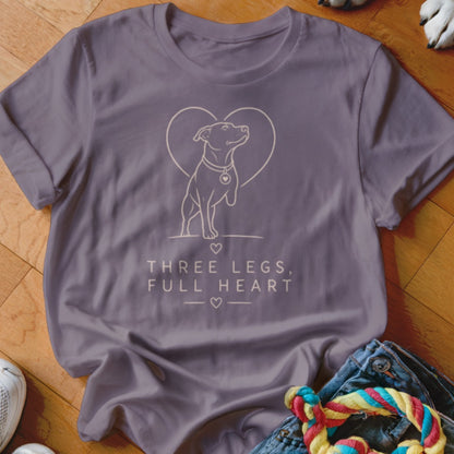 Purple t-shirt with graphic of three-legged dog, heart, and text "THREE LEGS, FULL HEART".