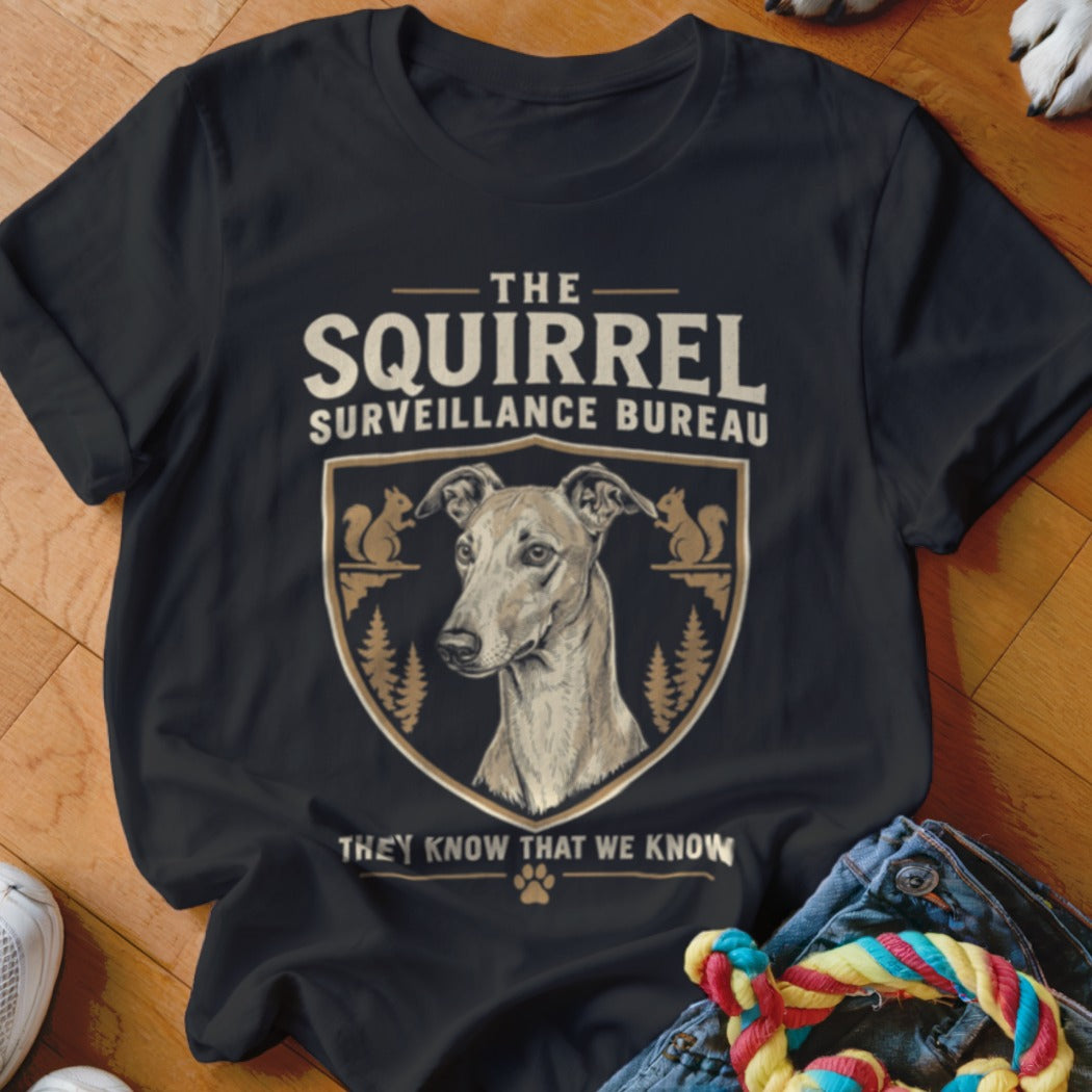 Black t-shirt featuring a graphic of a greyhound inside a shield with squirrels and text reading The Squirrel Surveillance Bureau.