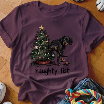 Black and tan dog lifting leg on Christmas tree with "naughty list" text.